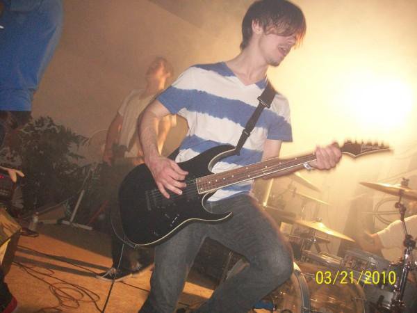 Joshua playing a guitar on stage at a performance