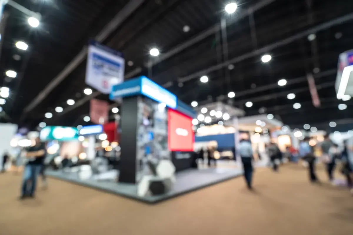 A blurred view of a corner booth at a tradeshow.