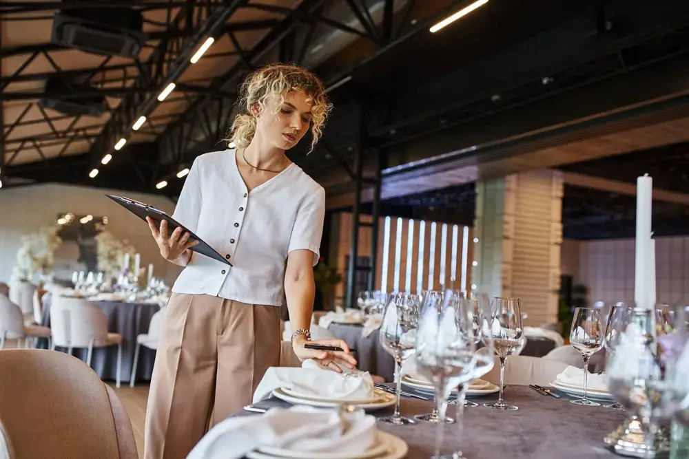 An event planner checking place settings before a banquet.